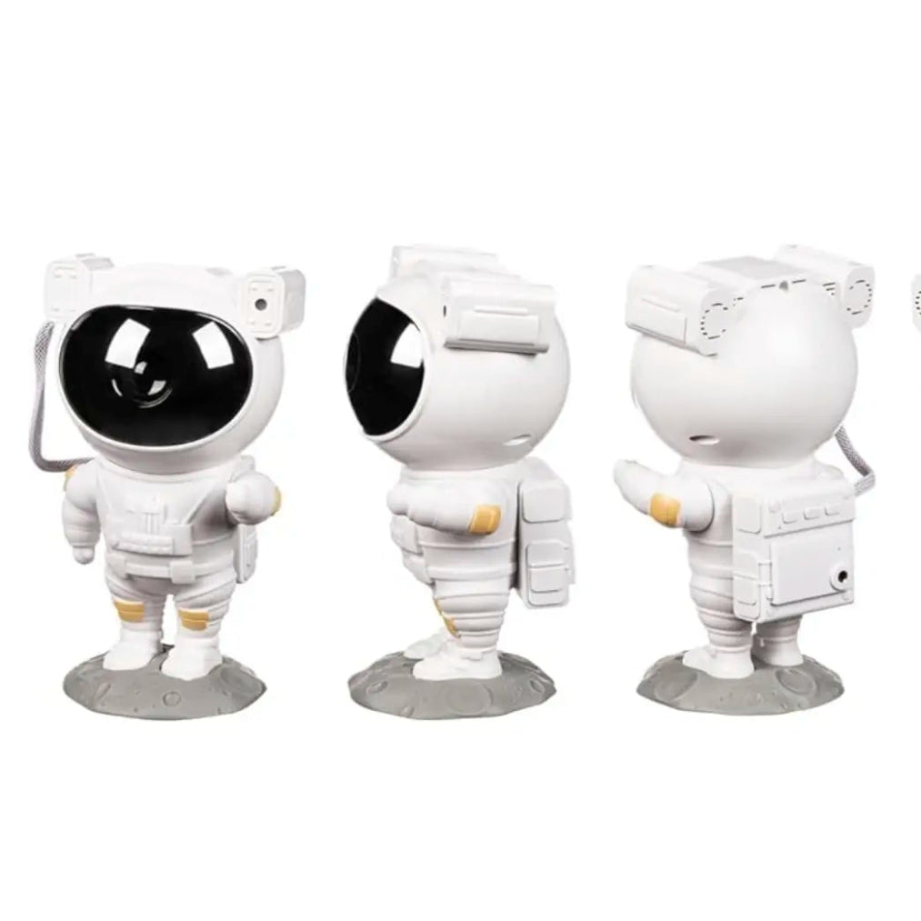 Astronaut-shaped night light projector projecting colorful lights on a ceiling, with a hand holding a remote control.