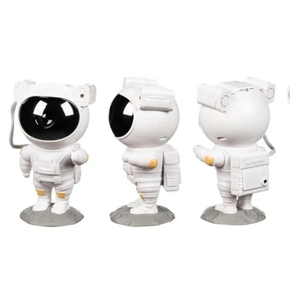 Astronaut-shaped night light projector projecting colorful lights on a ceiling, with a hand holding a remote control.